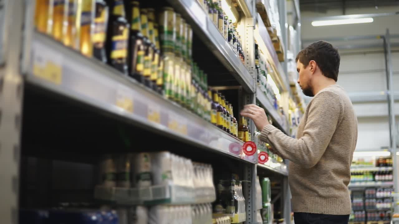 hombre comprando cerveza en la tienda de comestibles