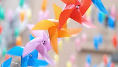 colourful plastic pinwheels rotate with blowing wind