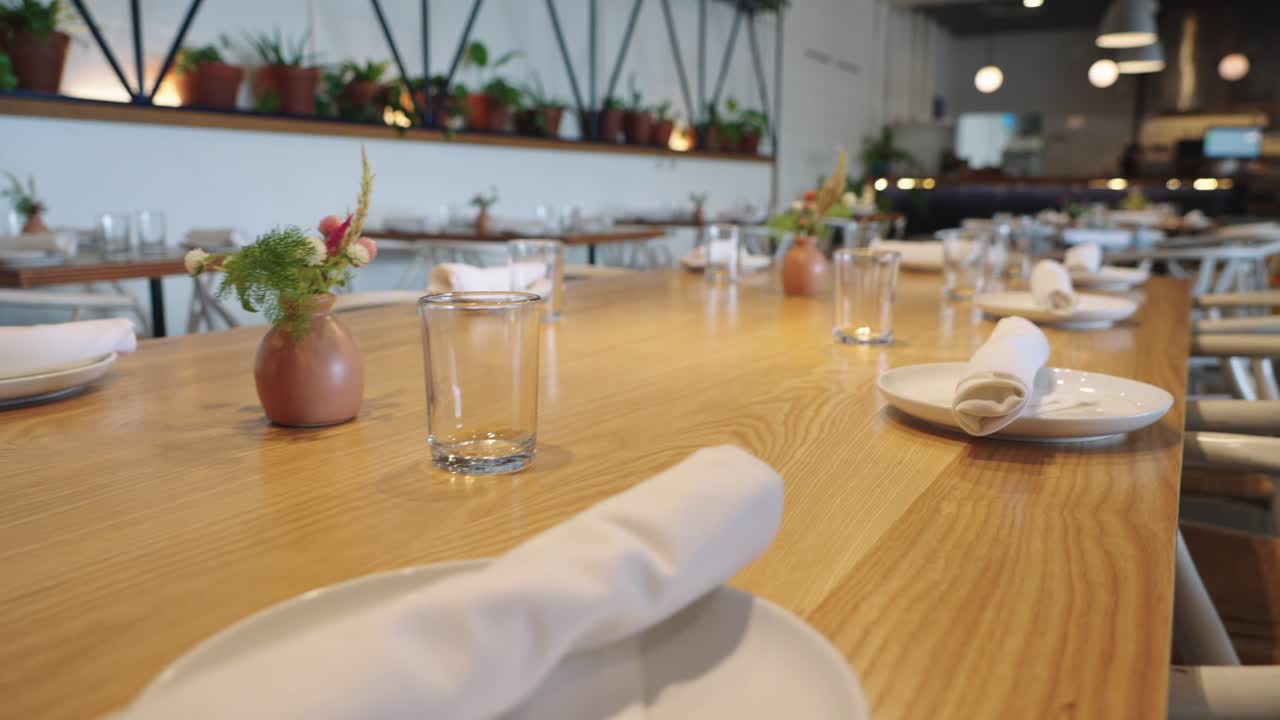 Rekaman 4K meja makan siang kayu besar yang elegan, ditata dan siap disajikan, menampilkan hidangan yang sudah ditata di piring, tata meja, dan presentasi santapan mewah