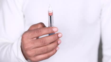 persona que sostiene una jeringa de insulina