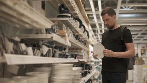 man shopping for dishes in a store