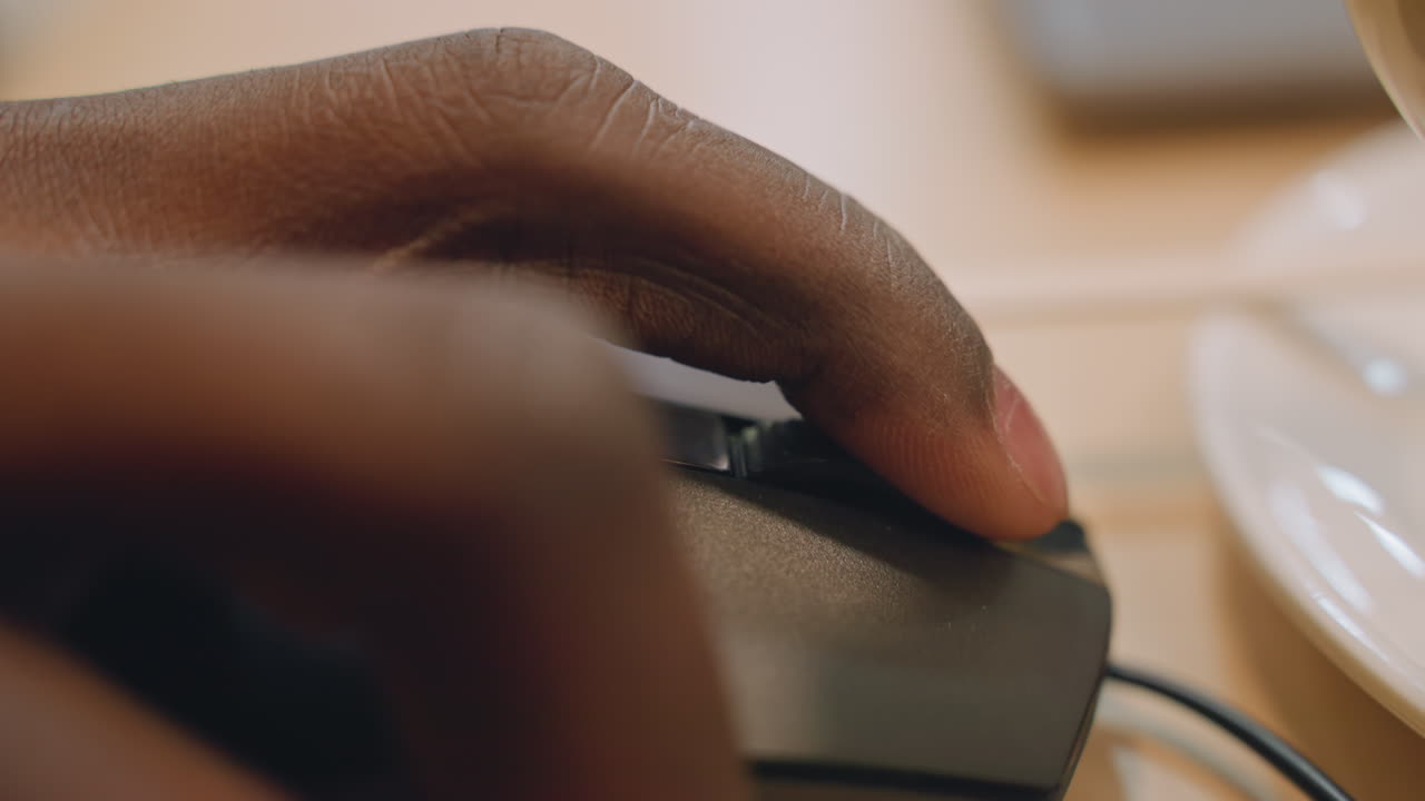 Closeup of hand navigating computer mouse. Person exploring online content during study in cafe setting. Individual skillfully controlling mouse while researching and browsing at coffeehouse table