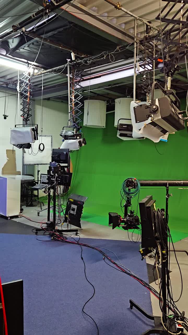 Filmovací scéna a televizní studio s kamerami a zeleným plátnem. Vertikální.