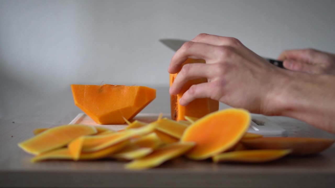 Slicing a big chunk of pumpkin in half and in smaller pieces