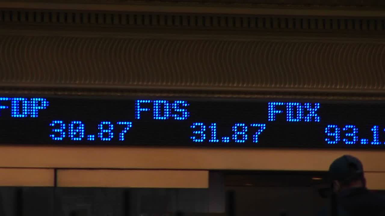 una cinta de teletipo abreviada muestra símbolos de acciones y su precio de cotización actual a medida que parpadea