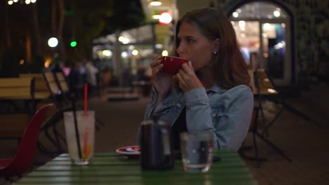 woman enjoying coffee at a night cafe