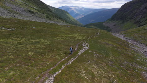 drone shot passing by solo hiker in beautiful mountain valley