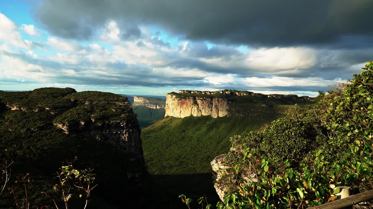 Tilting up shot revealing the stunning Capao Valley with large plateaus from the Mount of Pai Inácio hike in the Chapada Diamantina national park in northern Brazil on a warm summer evening