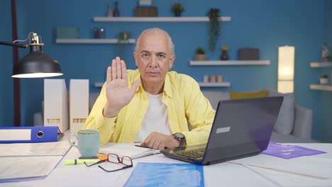 home office worker old man says stop to camera, warns.