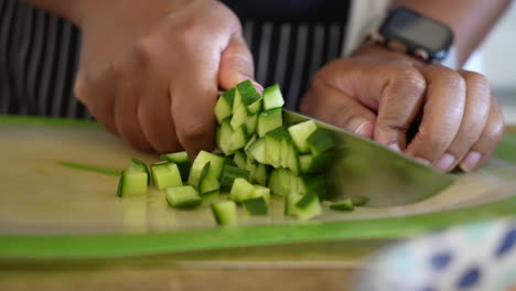 dicing cucumbers on a cutting board to add to tomato mixture for a chopped salad - antipasto salad series