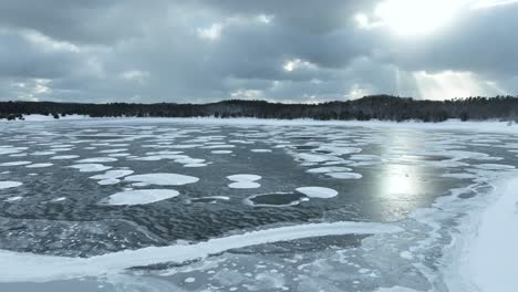 reverse track over a frozen lake with gorgeous cloud cover and light