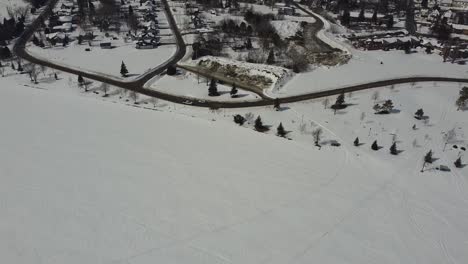 drone view of a snow dump in winter next to a lake