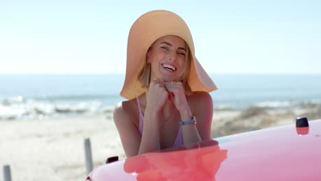 a young caucasian woman enjoys the beachside on a road trip