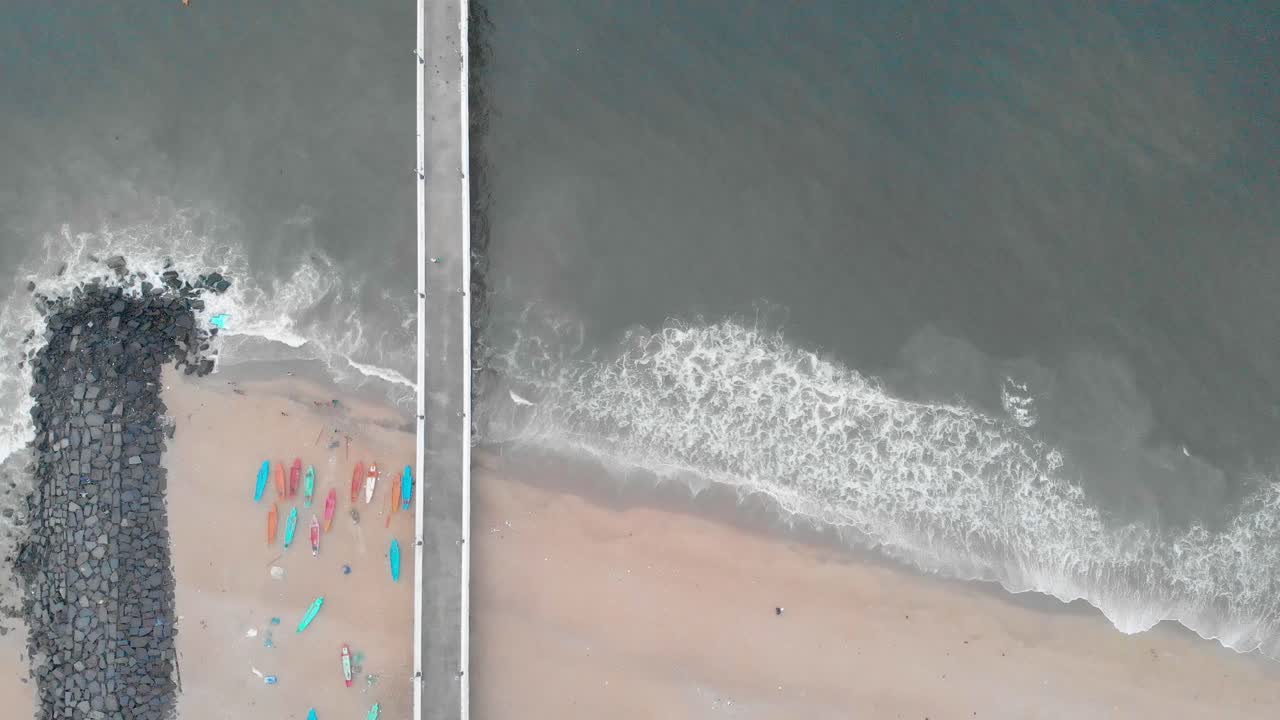 드론, 폰디체리, 인도와 함께 바위 해변 근처에 몬순 구름이 덮힌 일출에 선적항 부두의 4k 공중 하향식 삼각대 샷