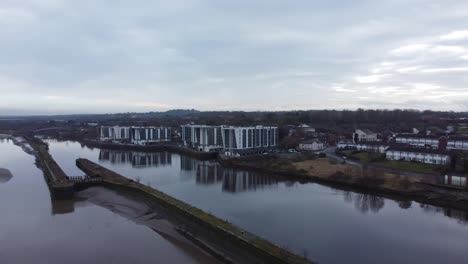 Early-morning-aerial-view-riverside-waterfront-contemporary-apartment-office-buildings-canal-regeneration-real-estate-rising-tilt-down