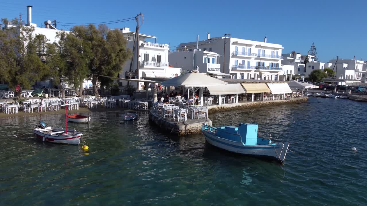 Aerial Orbit of Marina Cafe Terrace with Tourists in Aliki Village, Paros