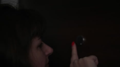 worried woman looking through the peephole in theevening, eye close-up