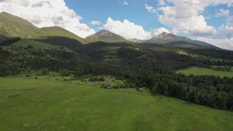 el impresionante campo de hierba y las altas montañas del valle del paraíso de montana, panorámica aérea