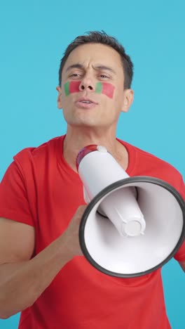 excited man with portuguese flag on face using a megaphone