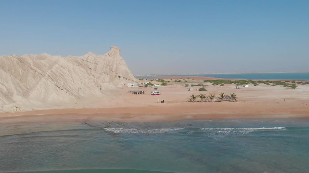영화적 관점 사람들이 해변을 즐기고 있고 바다 파도가 부서지고 있다