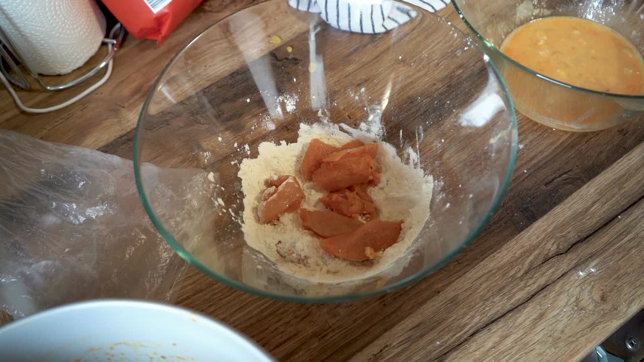 mujer carne empanada pechuga de pollo en un mostrador de cocina