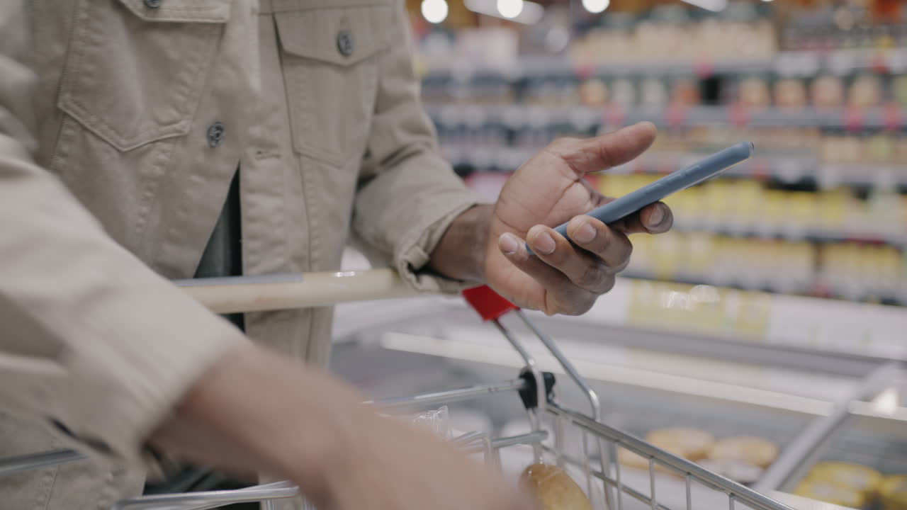 Man Shopping Using Smartphone in Grocery Store