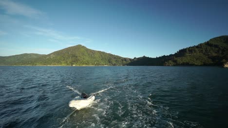 SLOWMO---Towing-dingy-with-rope-behind-boat-in-Marlborough-Sounds,-New-Zealand