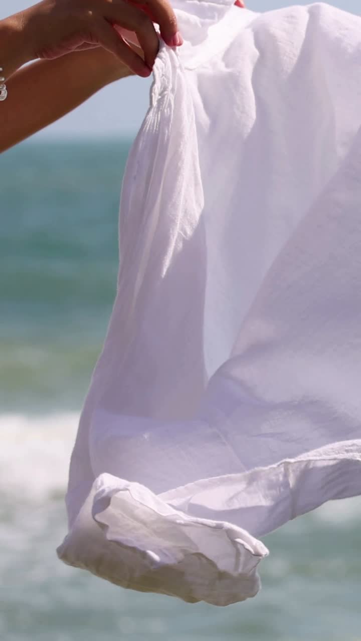 바다의 물결을 배경으로 색 시트가 흔들리고 있습니다.