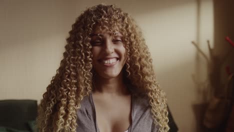 close-up portrait of a happy young woman with curly hair smiling