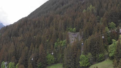 Luftaufnahme-Einer-Gondel-In-Einem-Grasbewachsenen-Tal,-Das-Zu-Einer-Kleinen-Stadt-Führt