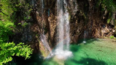 drammatica clip drone che inizia sulla cascata, poi sale verso l'orbita dall'alto verso il basso, finendo con la rivelazione inclinata verso l'alto di splendidi laghi di plitvice