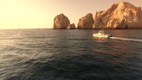 imágenes de drones en el arco de cabo san lucas, méxico, siguiendo un barco navegando por el agua