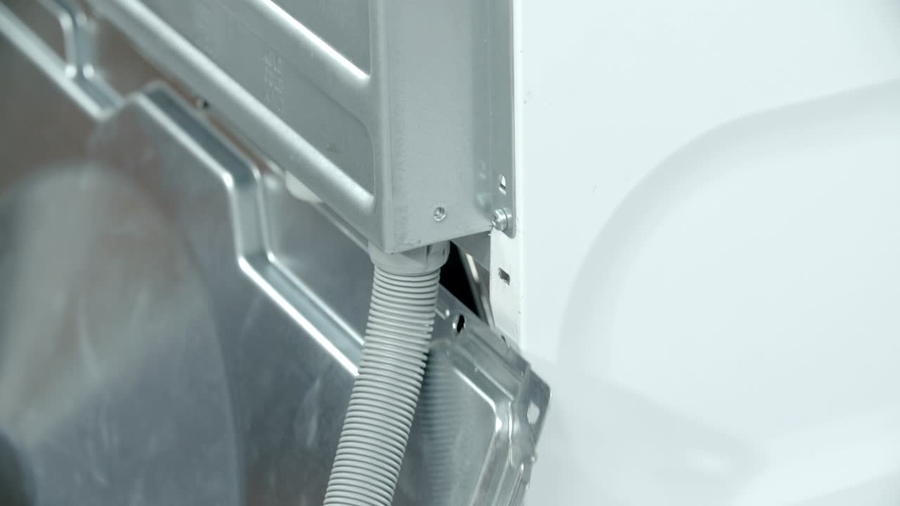 reparador quitando el panel lateral trasero de la lavadora