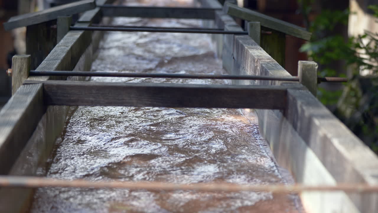 자연에서 오래 된 성 방향 물 방앗간에서 흐르는 물의 총을 닫습니다