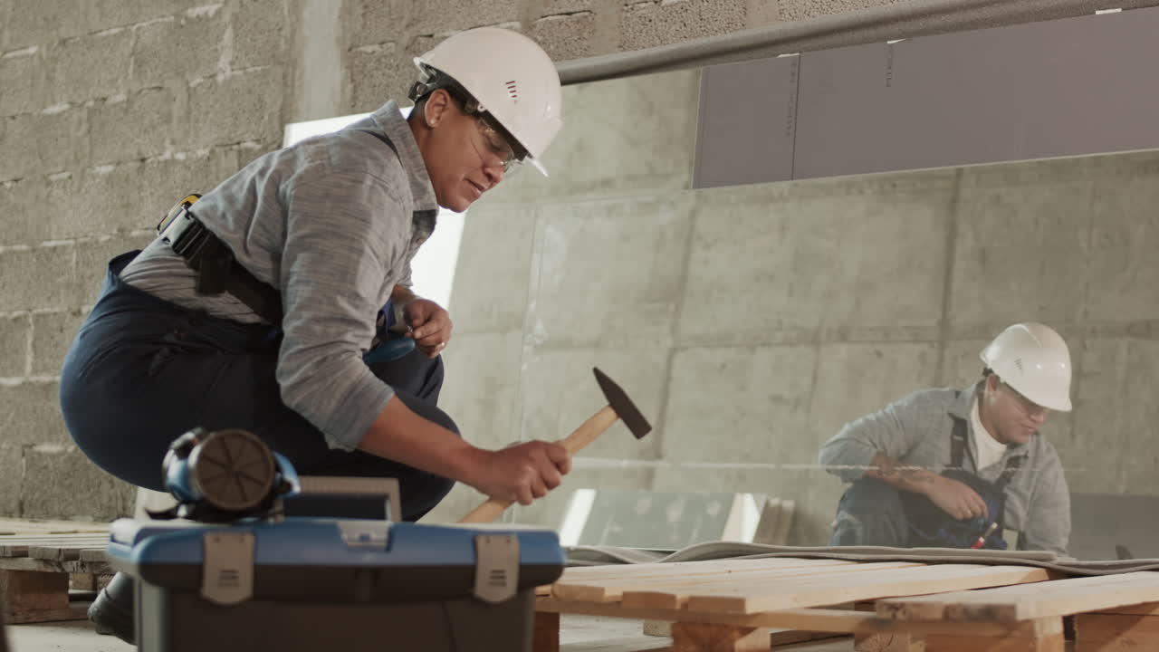 trabajador de la construcción biracial martillando hacia abajo