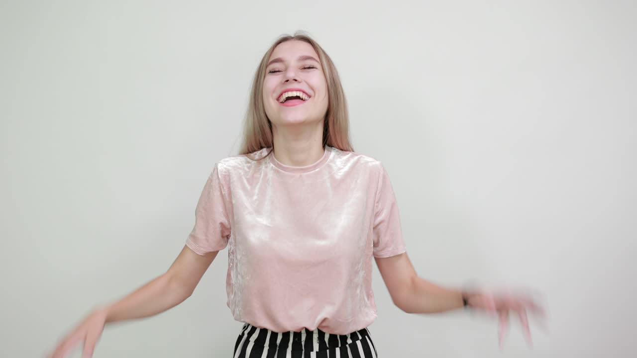 매우 행복하고 흥분한 여인이 팔을 들어 웃으며 우승자 제스처를 하고 있습니다.