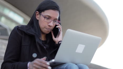empleada sonriente y confiada con gafas hablando por teléfono
