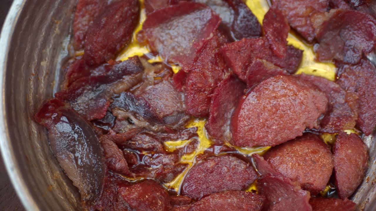 sucuk frito en una sartén