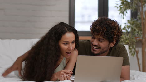 couple enjoying some online time together in bed