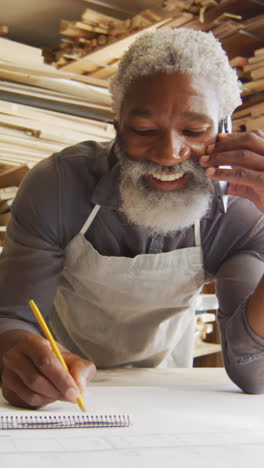 african american craftsman sketches designs in a woodshop