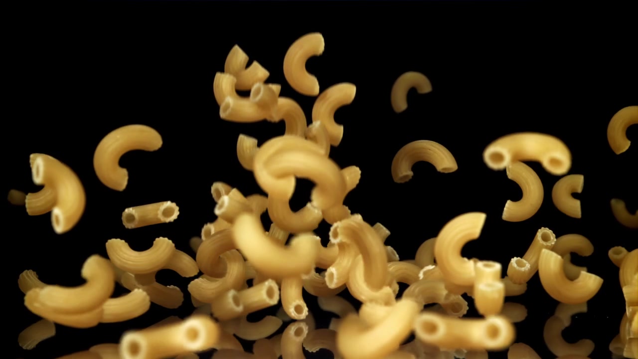 Maccheroni che cadono al rallentatore su sfondo nero