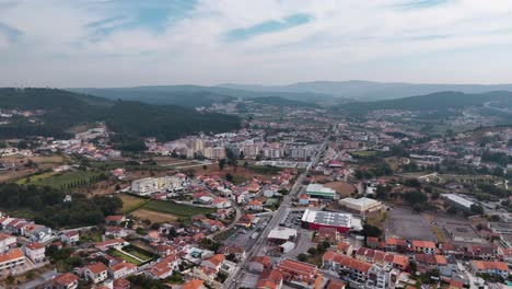 aerial - main street running through alfena village with homes, buildings, and hills in portugal