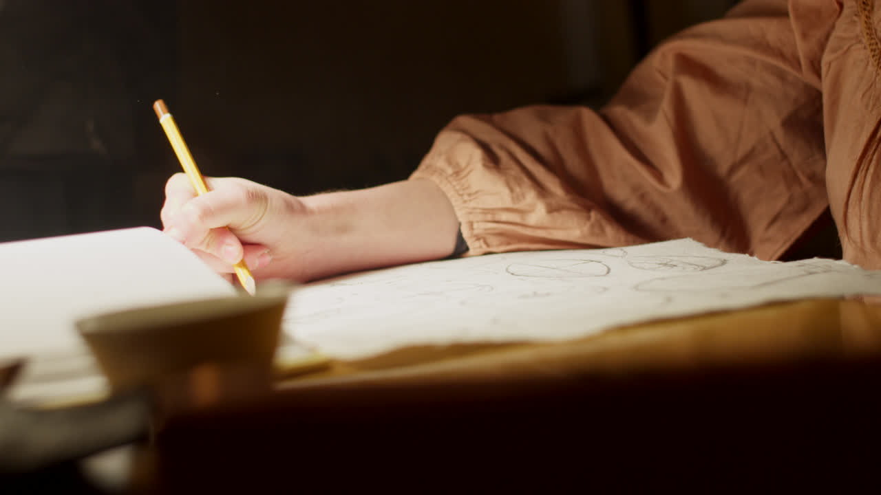 Woman studying and drawing at night