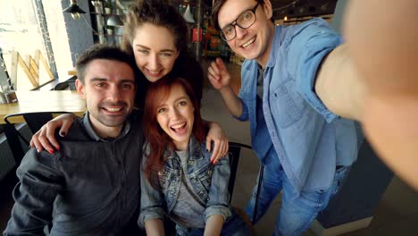 punto de vista de amigos alegres tomando selfies en una pizzería posando y sonriendo, riendo y gestando juntos. concepto de amistad y personas felices.