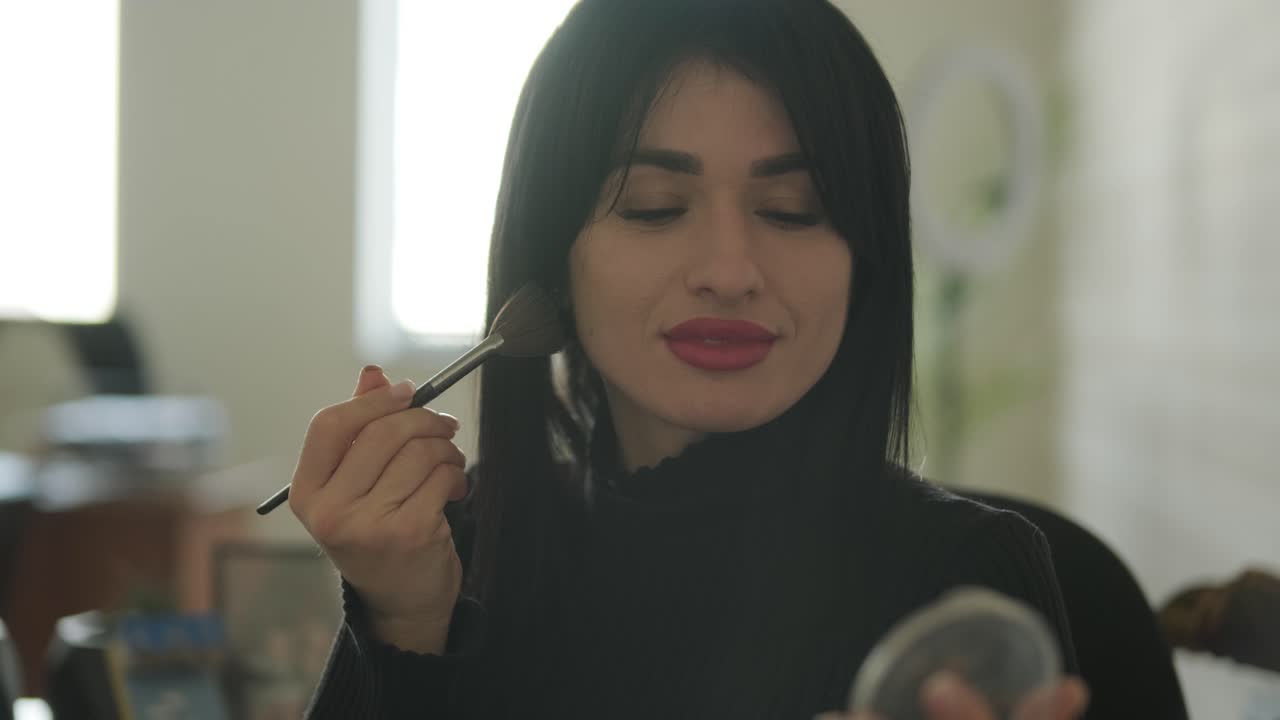 mujer de negocios profesional en su oficina aplicando maquillaje, vestida con elegantes trajes de negocios, equilibrando el cuidado personal y las responsabilidades laborales en un entorno de oficina moderno