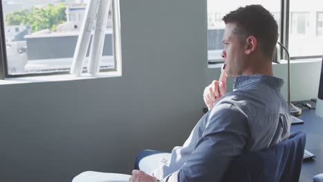 Businessman-looking-away-in-modern-office