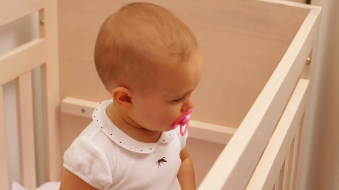 귀여운 침대에서 서 있는 아기 소녀