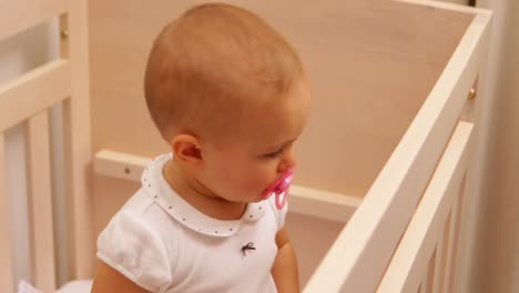 cute baby girl standing in her cot