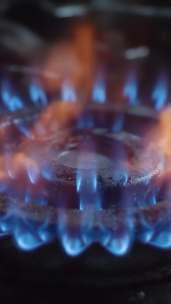 Intense Flames Dancing from a Gas Burner: A Close-Up View Capturing the Vivid Blue and Orange Glow of Fire, Reflecting Heat and Energy in an Enigmatic Display