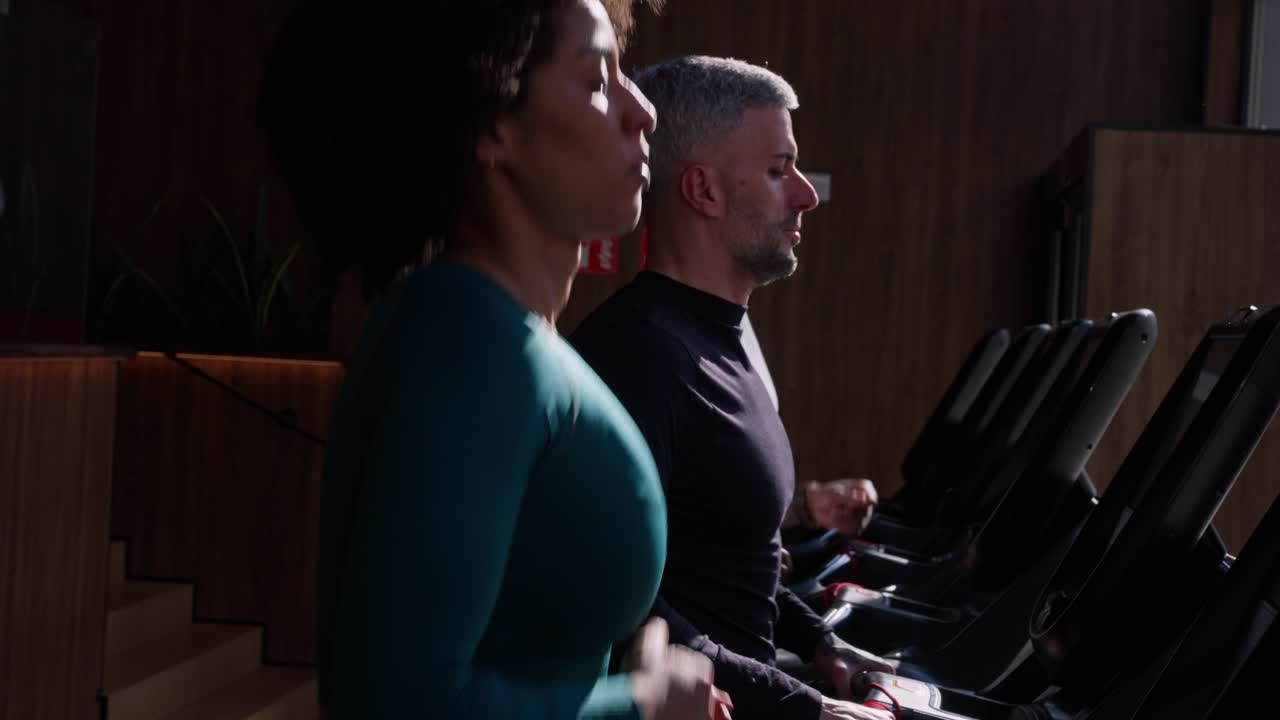 Woman and Man Running on Treadmills in Modern Gym